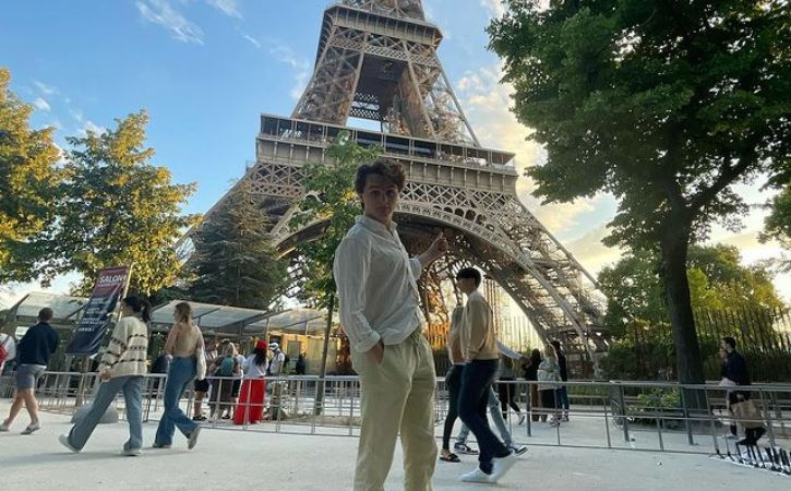 Wil Deusner posing for a picture infront of Eiffel Tower.